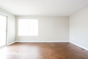 University Park house for rent - an empty room with white walls and a window and wood floors