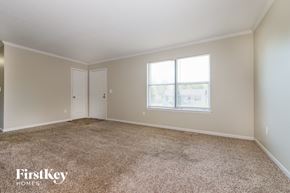 Peculiar house for rent - an empty living room with carpet and a window