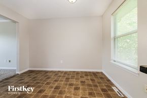 Peculiar house for rent - the living room of a home with a large window and tiled floors
