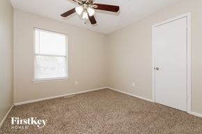 Peculiar house for rent - a bedroom with a ceiling fan and a white door