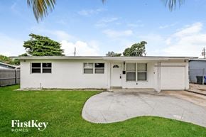 Fort Lauderdale house for rent - a small white house with a yard and a driveway