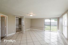 Fort Lauderdale house for rent - an empty living room with a sliding glass door to a yard