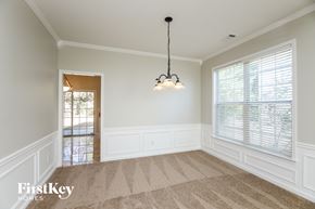 Woodstock house for rent - an empty dining room with two windows and a chandelier