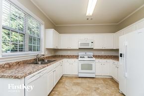 Woodstock house for rent - a kitchen with white appliances and granite counter tops
