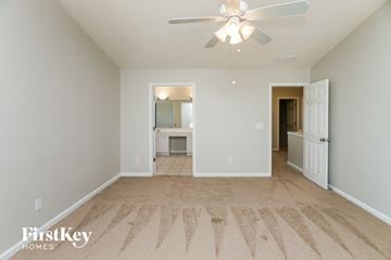 Woodstock house for rent - a spacious living room with carpet and a ceiling fan