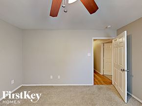 Grand Prairie house for rent - a bedroom with a door to a hallway and a ceiling fan