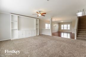 Winston-Salem house for rent - A spacious living room with a staircase leading to the upper floor.