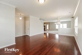 Winston-Salem house for rent - A spacious room with wooden floors and white walls.
