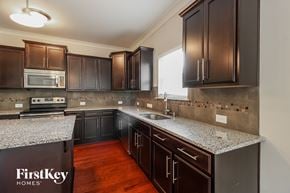 Winston-Salem house for rent - A kitchen with dark brown cabinets and a granite countertop.