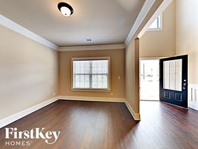 Loganville house for rent - an empty living room with hardwood flooring and a window