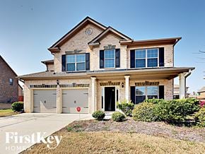 Loganville house for rent - a house with two garage doors and a sidewalk in front of it