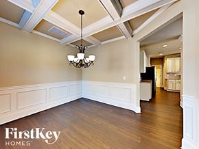 Loganville house for rent - an empty dining room with white walls and a chandelier