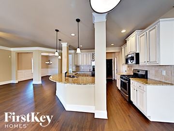Loganville house for rent - an open kitchen with white cabinets and granite counter tops