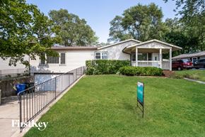 Carpentersville house for rent - A house with a sign that says "First Key" in front of it.