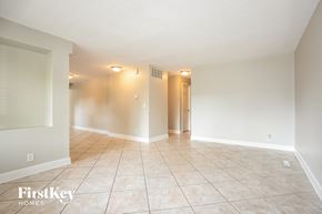 Carpentersville house for rent - A spacious room with tiled flooring and a doorway leading to another room.