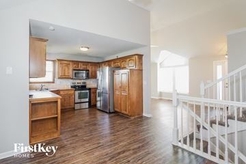 Belton house for rent - A kitchen with wooden cabinets and a white fridge.