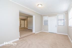 Cocoa house for rent - A room with a carpeted floor and a white door.