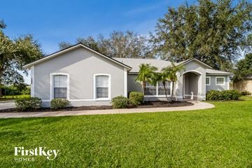 Minneola house for rent - a white house with palm trees in front of it