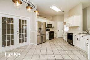 Minneola house for rent - a kitchen with white cabinets and stainless steel appliances