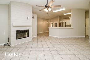 Minneola house for rent - an empty living room with a fireplace and a ceiling fan
