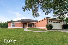 Kissimmee house for rent - a brick house with a lawn and a white garage door