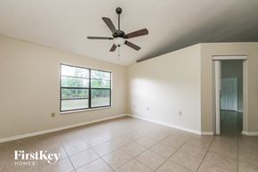 Kissimmee house for rent - an empty living room with a ceiling fan and a large window