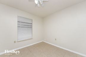 Kissimmee house for rent - a spacious living room with a ceiling fan and a window