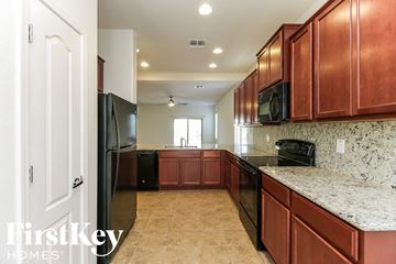 San Tan Valley house for rent - A kitchen with brown cabinets and a black fridge.