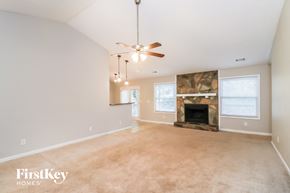 Woodstock house for rent - A spacious living room with a fireplace and a ceiling fan.