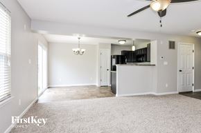 Wentzville house for rent - A spacious living room with a ceiling fan and a chandelier.
