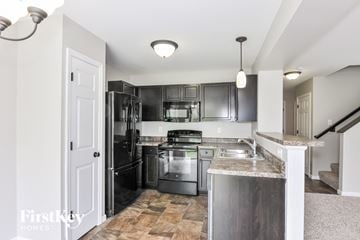 Wentzville house for rent - A kitchen with a stainless steel refrigerator, oven, and sink.