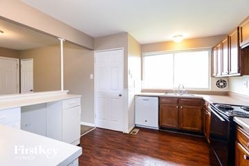 Florissant house for rent - a kitchen with white cabinets and a stove and a window