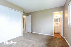 Florissant house for rent - a bedroom with a carpeted floor and a door to a bathroom