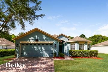 Auburndale house for rent - a house with a green garage door in front of a lawn