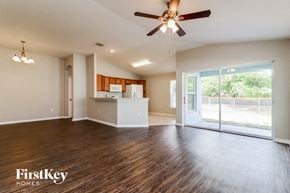 Auburndale house for rent - an empty living room with a ceiling fan and a kitchen