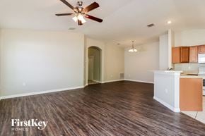 Auburndale house for rent - an empty living room and kitchen with a ceiling fan