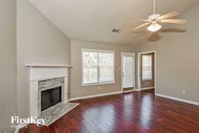Lawrenceville house for rent - A spacious room with a fireplace and hardwood floors.