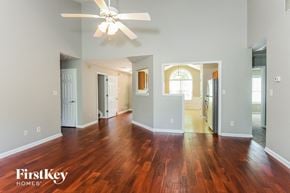 Lawrenceville house for rent - A spacious room with wooden floors and a ceiling fan.