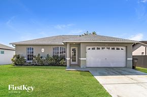 Cape Coral house for rent - a beige house with a garage door and a lawn