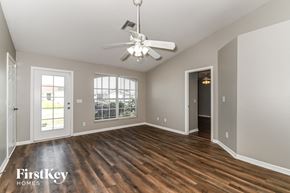 Cape Coral house for rent - an empty living room with wood floors and a ceiling fan
