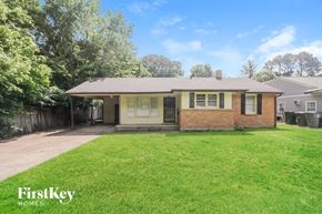 Memphis house for rent - a small brick house with a yard and a driveway