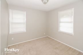Memphis house for rent - a bedroom with two windows and a carpeted floor