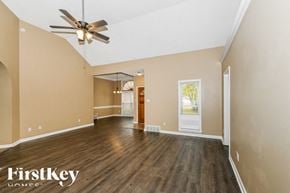 Cordova house for rent - A spacious room with a ceiling fan and wooden flooring.