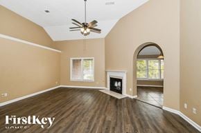 Cordova house for rent - A spacious room with a fireplace and a ceiling fan.
