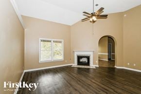 Cordova house for rent - A spacious room with a fireplace and a ceiling fan.