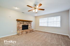 Winter Springs house for rent - A living room with a fireplace and a ceiling fan.