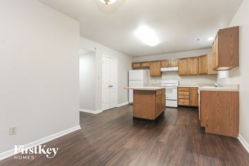 Indianapolis house for rent - A kitchen with wooden cabinets and a white fridge.