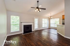 Mcdonough house for rent - an empty living room with a fireplace and a ceiling fan