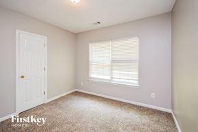 Mcdonough house for rent - a bedroom with carpet and a white door and a window