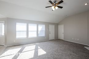 Rockwall house for rent - an empty living room with a ceiling fan and window